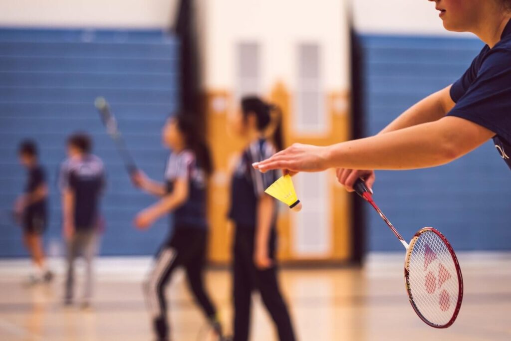 Badminton badminton på bana med gul fjäder