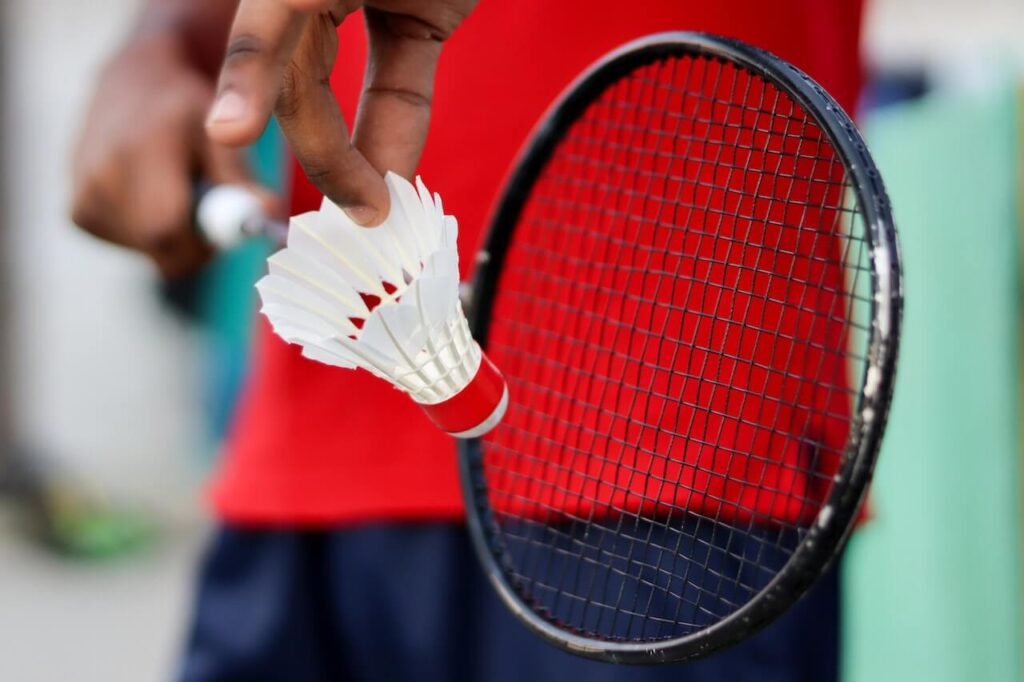 Badminton fjäder håller i badmintonboll