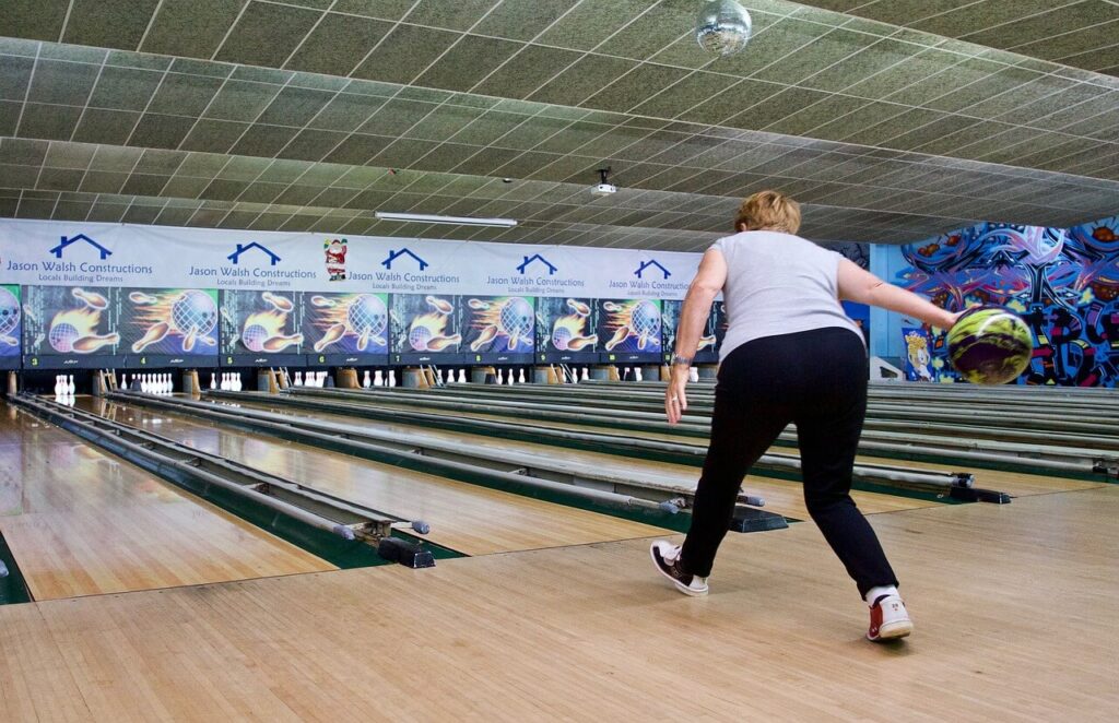 spelare använder bowlinghandske i Bollnäs för att kasta klot på banan när hon bowlar