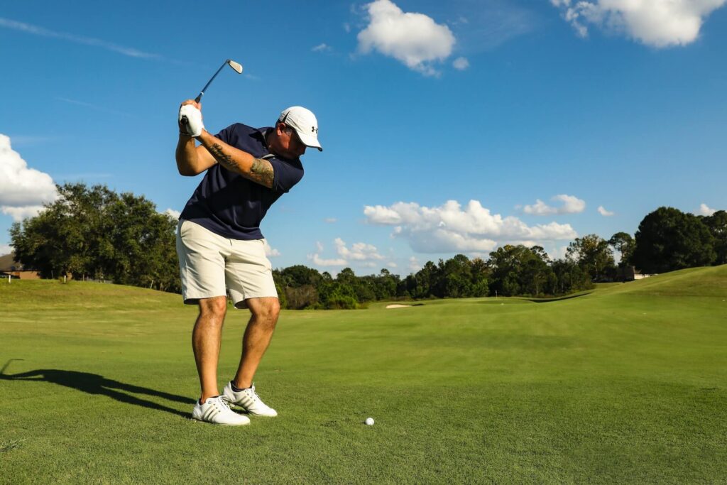 spelare slår golfboll